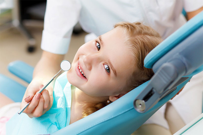 little girl sitting in dental chair